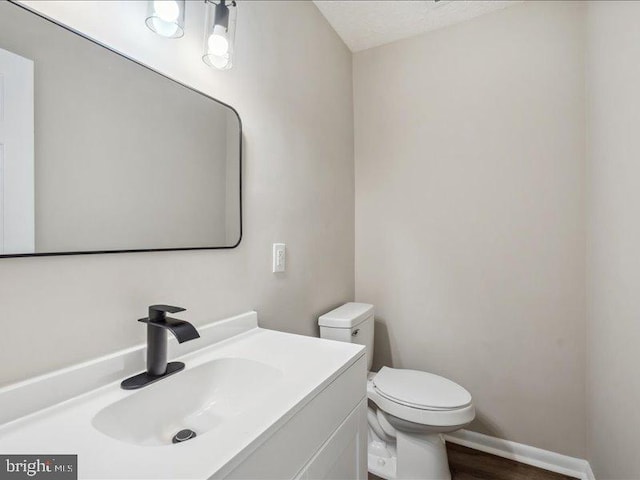 bathroom with vanity, a textured ceiling, toilet, and hardwood / wood-style flooring