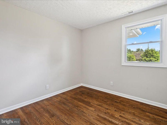 spare room featuring hardwood / wood-style floors and a textured ceiling