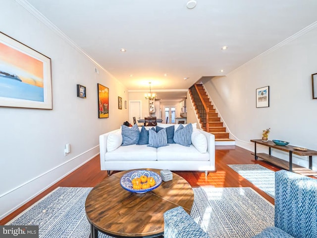 living room featuring crown molding, hardwood / wood-style flooring, and a chandelier