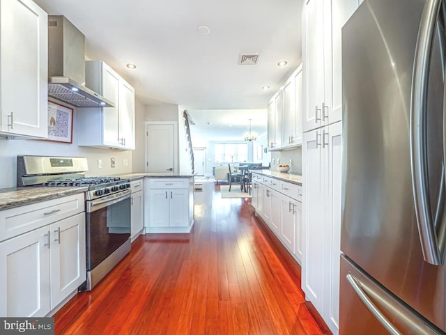 kitchen with wall chimney exhaust hood, white cabinetry, stainless steel appliances, and dark hardwood / wood-style floors