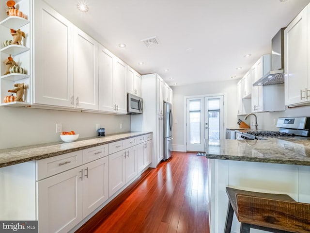 kitchen with stainless steel appliances, light stone countertops, and white cabinets