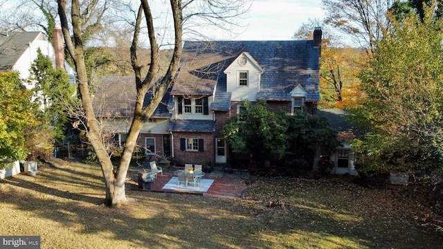 rear view of house featuring a patio area and a lawn