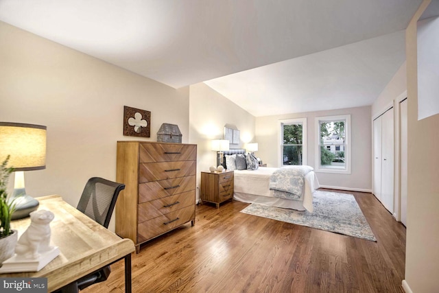 bedroom featuring a closet, wood-type flooring, and vaulted ceiling