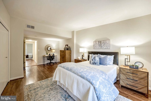 bedroom with dark hardwood / wood-style floors and a closet