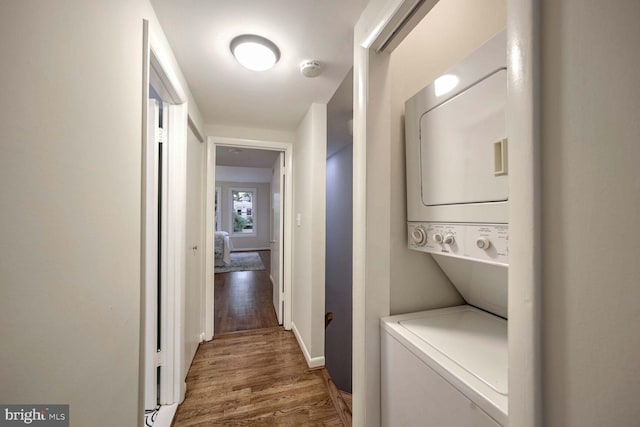 washroom with stacked washer and dryer and dark hardwood / wood-style floors