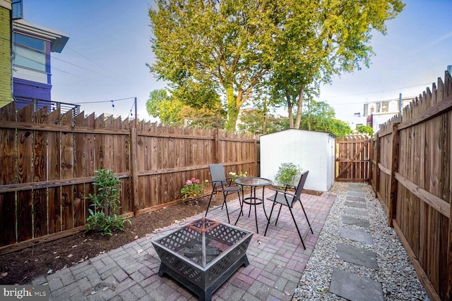 view of patio featuring a storage shed and a fire pit