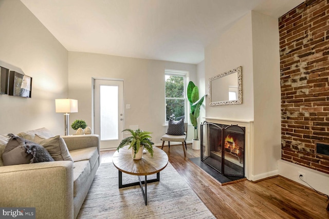 living room with hardwood / wood-style floors and a large fireplace