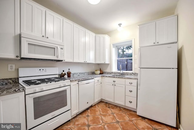 kitchen featuring white cabinetry, light stone countertops, and white appliances