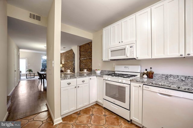 kitchen with white cabinetry, light stone countertops, light wood-type flooring, and white appliances