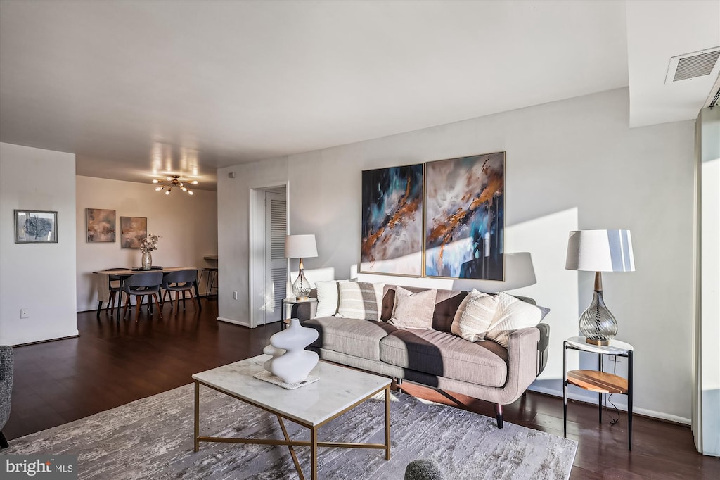 living room featuring a notable chandelier and dark hardwood / wood-style floors