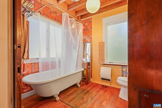 bathroom featuring toilet, beam ceiling, wood-type flooring, and a washtub