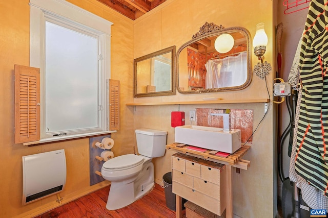 bathroom featuring toilet, hardwood / wood-style floors, vanity, and heating unit