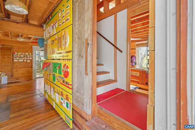 stairs featuring hardwood / wood-style flooring and wooden walls