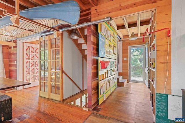 interior space with hardwood / wood-style floors and wooden walls