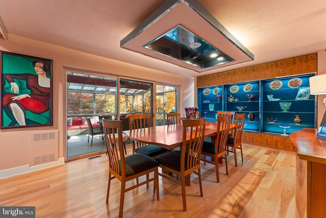 dining room with hardwood / wood-style floors and a textured ceiling