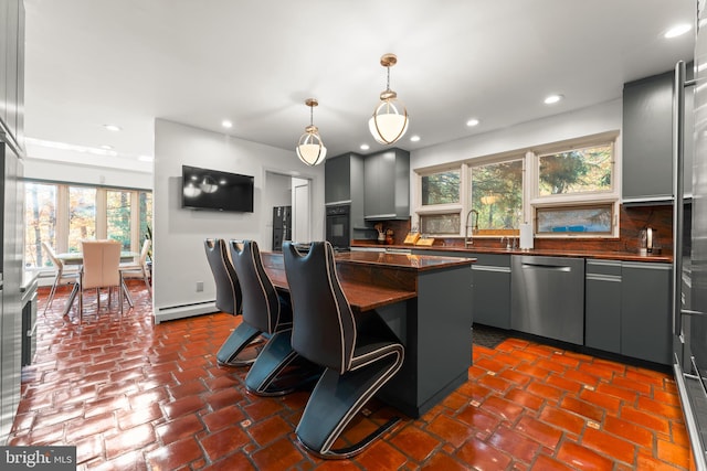 kitchen featuring tasteful backsplash, dishwasher, gray cabinetry, decorative light fixtures, and a center island