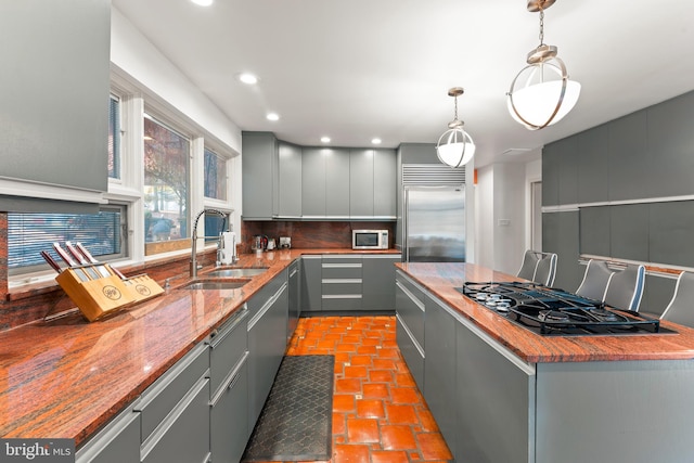 kitchen with appliances with stainless steel finishes, gray cabinetry, sink, and pendant lighting