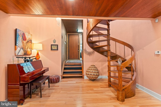 stairs with wood-type flooring and wooden ceiling