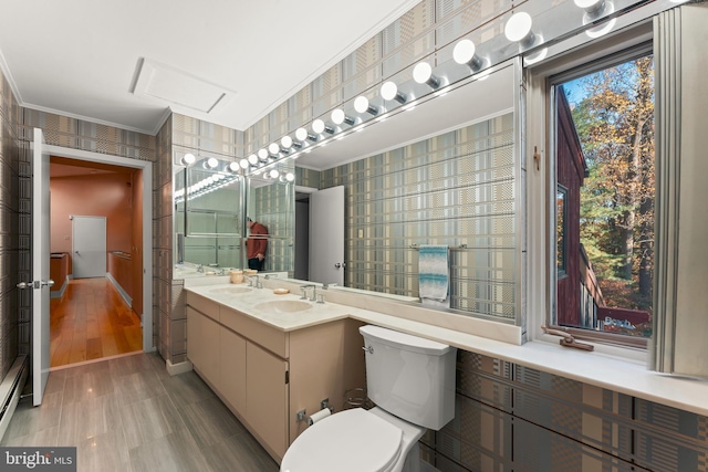 bathroom featuring vanity, ornamental molding, hardwood / wood-style flooring, and toilet