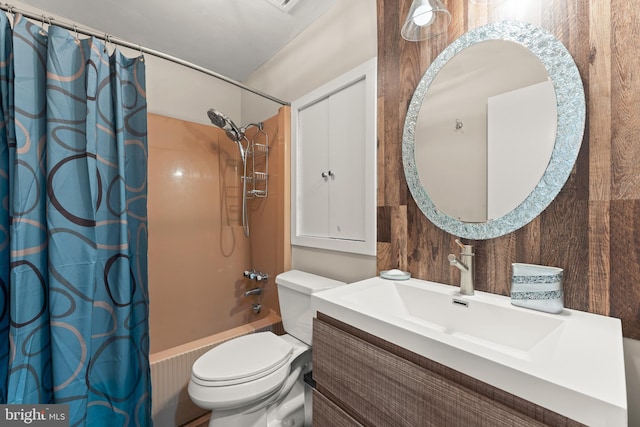 full bathroom featuring vanity, shower / bath combo, toilet, and wood walls