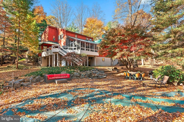 rear view of property featuring a sunroom