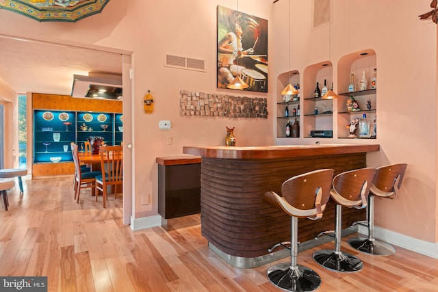 bar with light hardwood / wood-style flooring