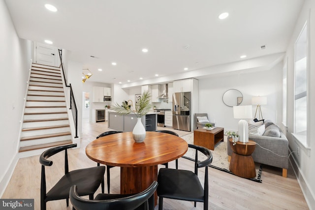 dining space featuring wine cooler and light hardwood / wood-style flooring