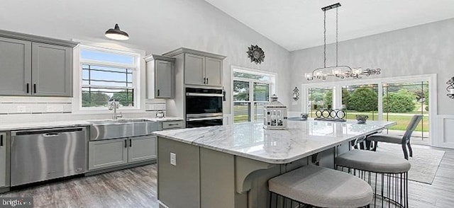 kitchen featuring a wealth of natural light, a center island, stainless steel appliances, high vaulted ceiling, and pendant lighting