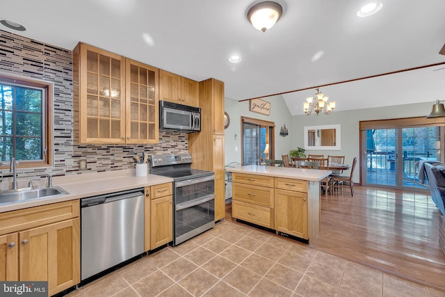 kitchen featuring tasteful backsplash, appliances with stainless steel finishes, light countertops, and a sink