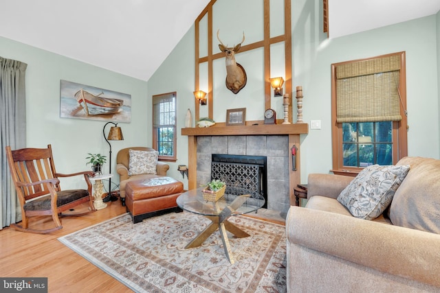 living room with wood finished floors, a fireplace, and high vaulted ceiling