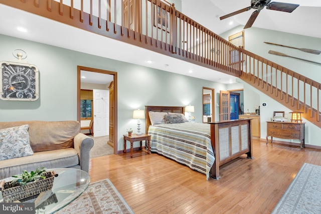 bedroom featuring light wood-style flooring, baseboards, and high vaulted ceiling