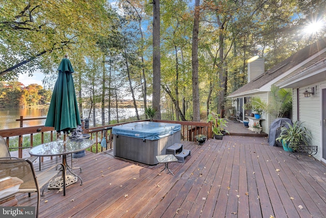 wooden terrace featuring a water view and a hot tub