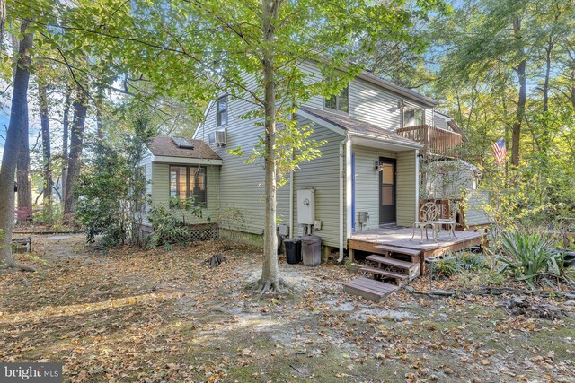 back of property with a deck and a balcony