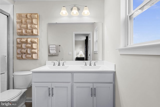 bathroom with vanity, an enclosed shower, plenty of natural light, and toilet