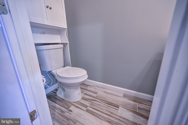 bathroom with wood-type flooring and toilet