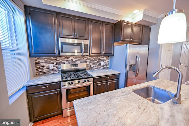 kitchen with appliances with stainless steel finishes, sink, and dark brown cabinets