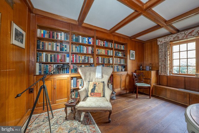 living area featuring hardwood / wood-style flooring, wood walls, beamed ceiling, built in shelves, and coffered ceiling