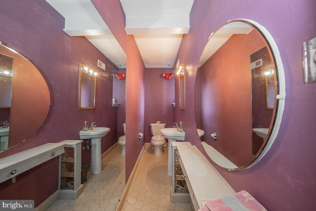 bathroom featuring beamed ceiling, sink, a bidet, and toilet