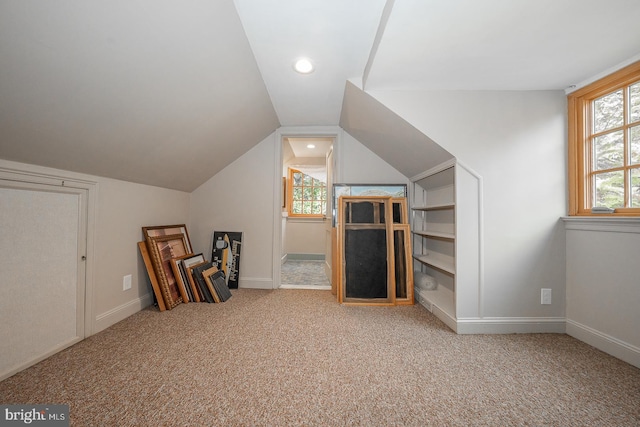 additional living space with vaulted ceiling and carpet floors