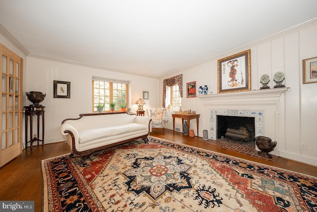 living room with a tiled fireplace, ornamental molding, and dark hardwood / wood-style flooring