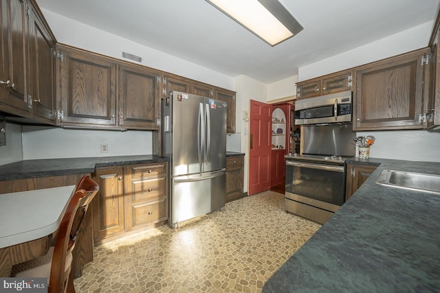 kitchen featuring dark brown cabinetry, appliances with stainless steel finishes, and sink