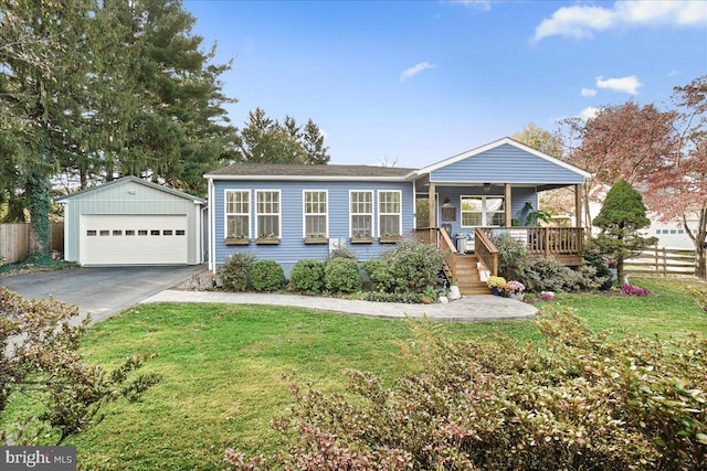 view of front of home featuring a front yard, an outbuilding, and a garage