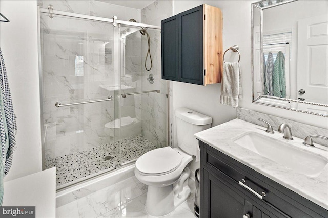 bathroom featuring vanity, toilet, and a shower with shower door