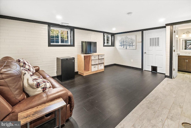 living room with brick wall and dark wood-type flooring