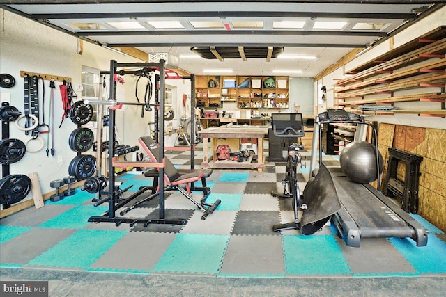 gym with a tile fireplace