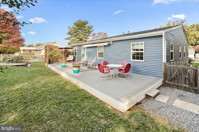 back of house featuring a wooden deck and a yard