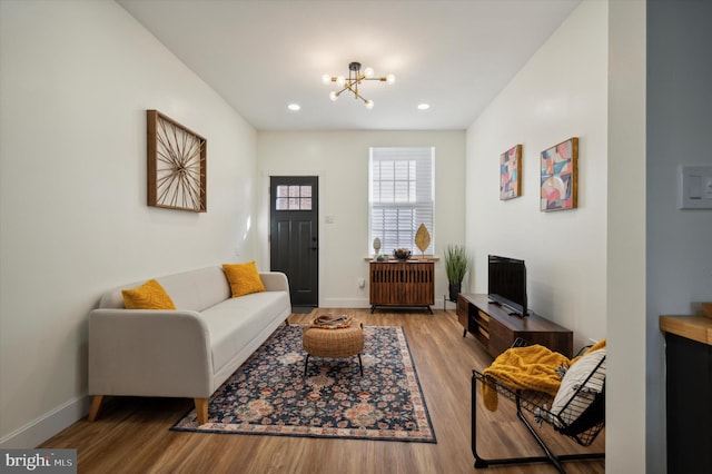 living room with a chandelier, wood-type flooring, and radiator heating unit