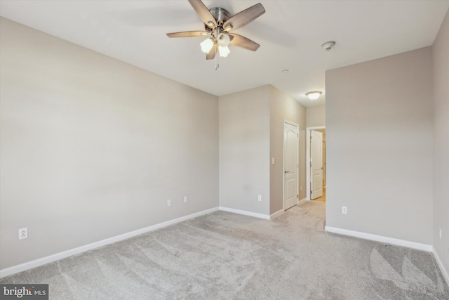 spare room with light colored carpet and ceiling fan