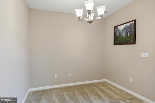 carpeted empty room featuring a notable chandelier