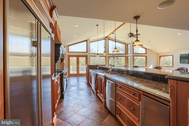 kitchen with appliances with stainless steel finishes, dark stone countertops, sink, french doors, and decorative light fixtures